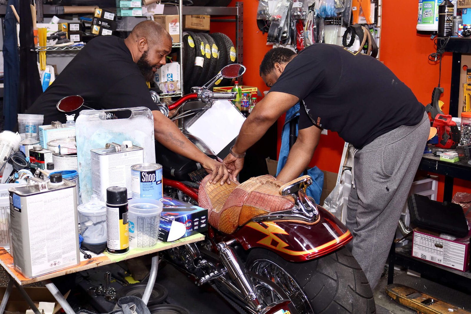 Two shop team members working on a custom motorcycle